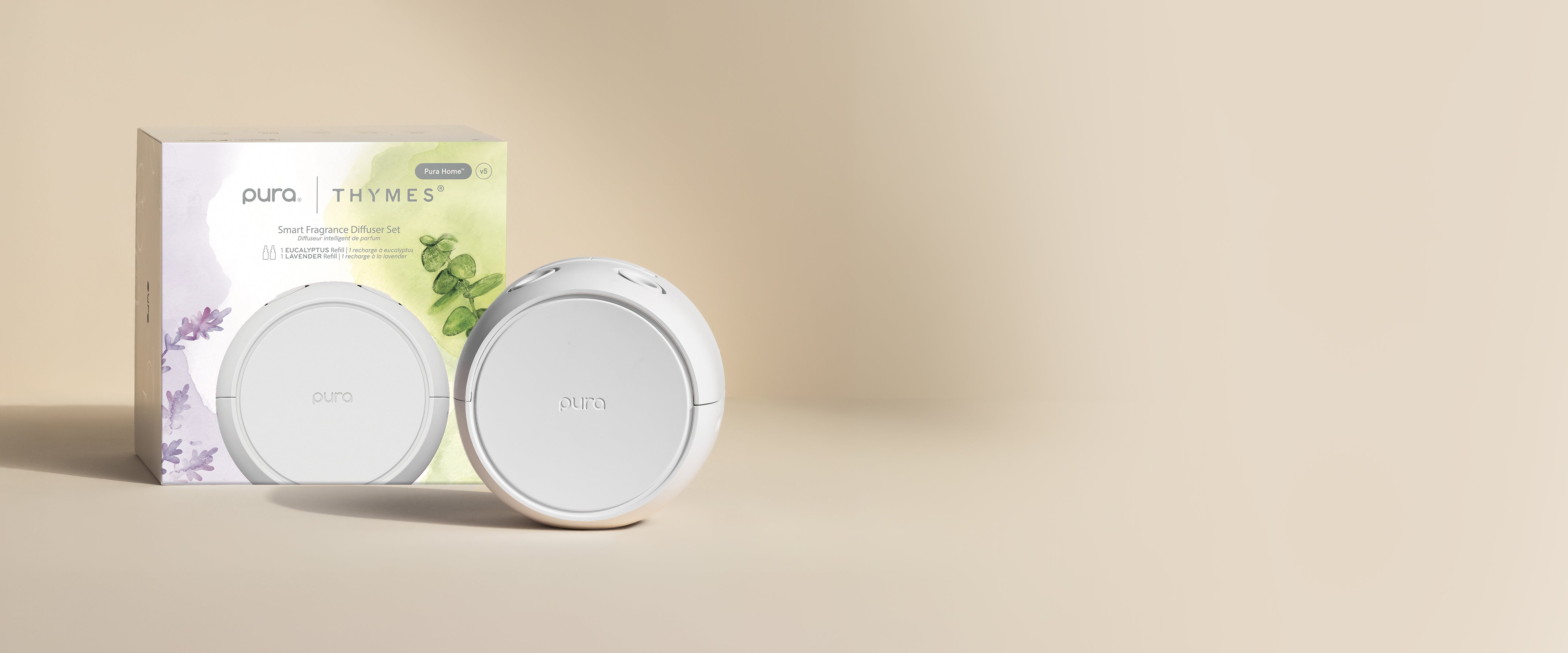 Two white circular devices with a packaging box featuring text and graphics on a beige background