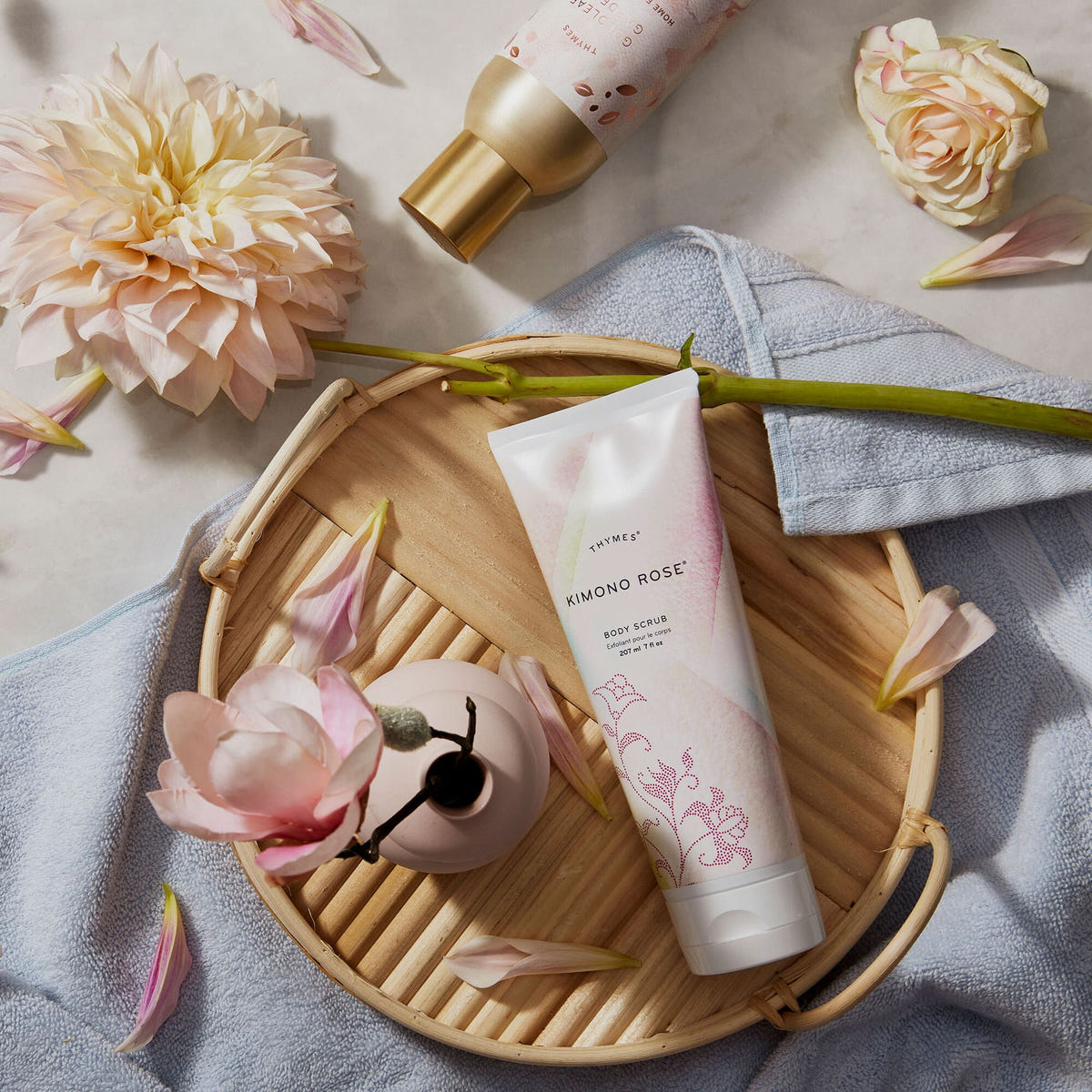 Alternate image of Thymes Kimono Rose Body Scrub for exfoliation flat lay on wooden tray next to beauty items