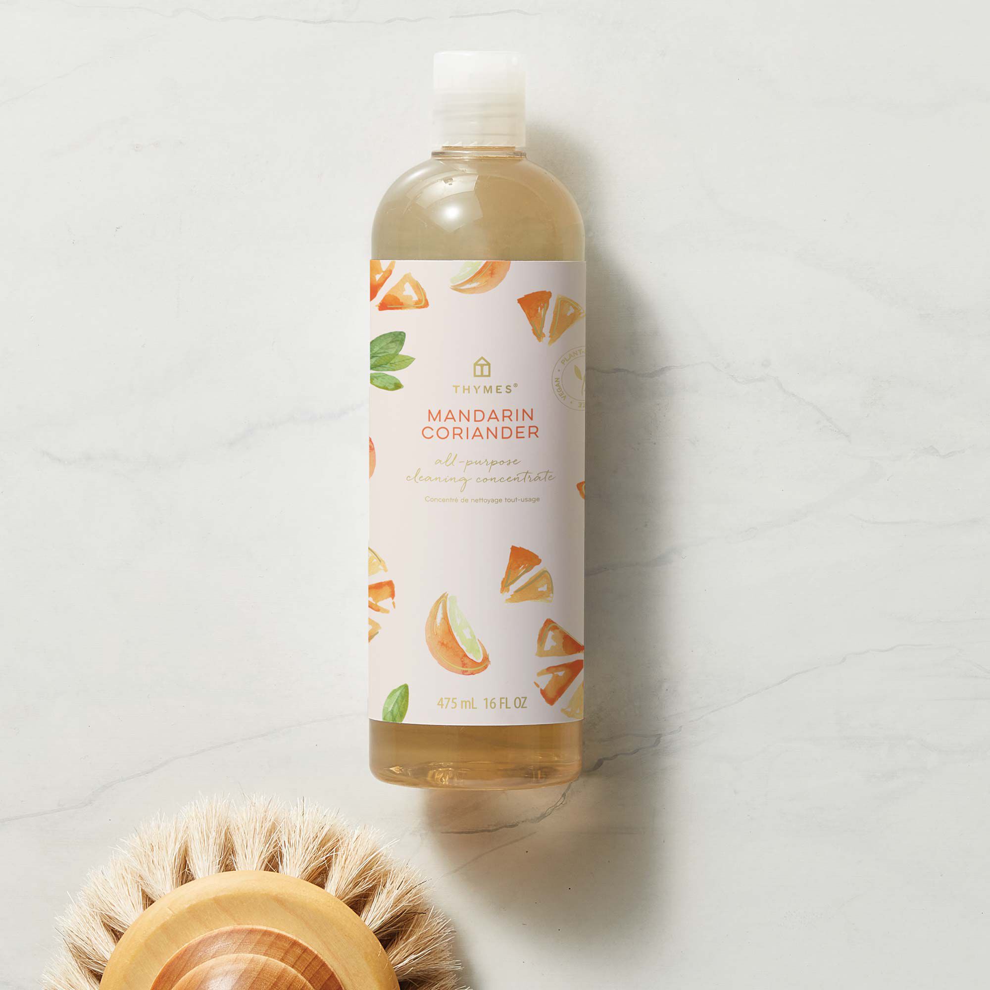 Thymes Mandarin Coriander All Purpose Cleaning Concentrate for Floors and Surfaces next to scrubber