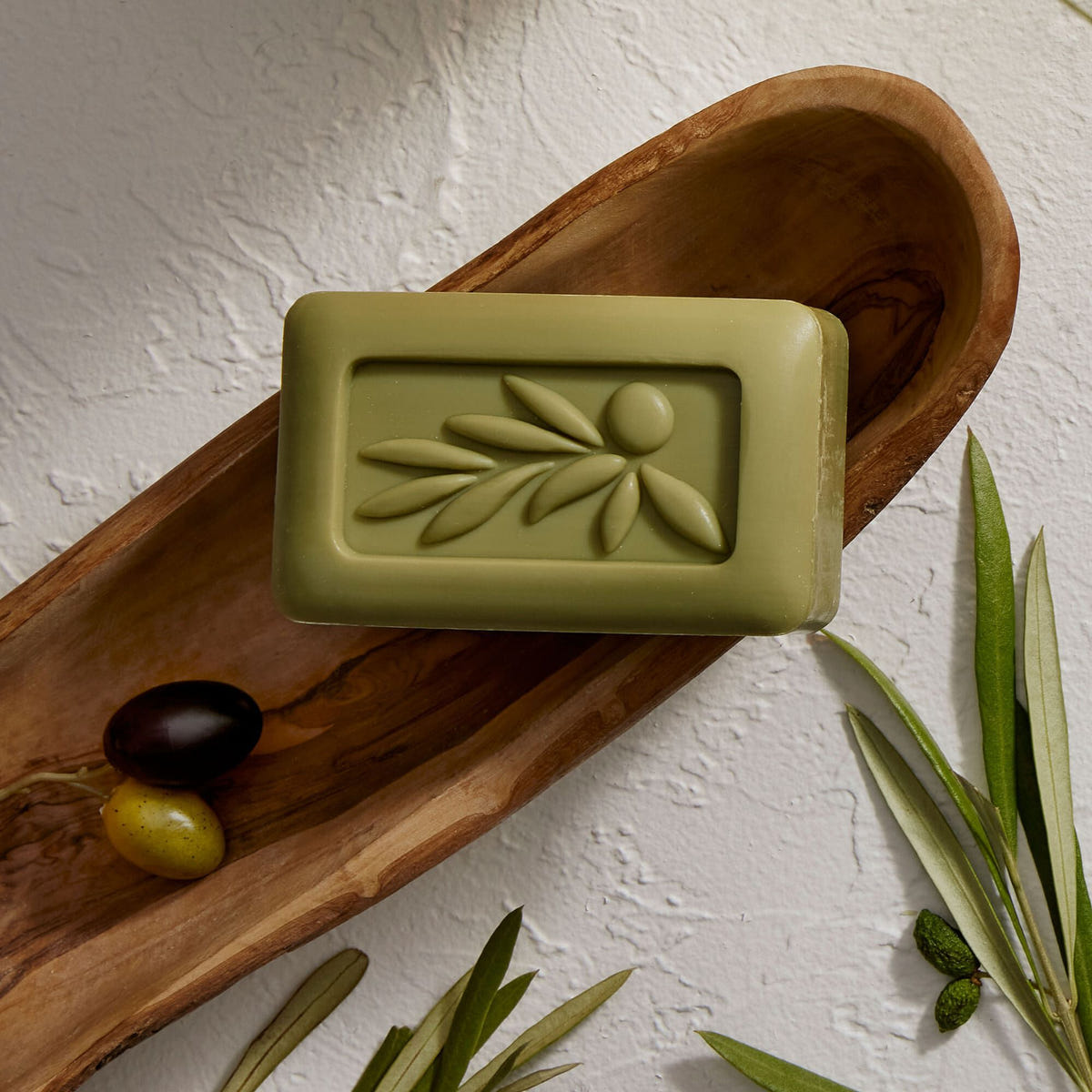Alternate image of Thymes Olive Leaf Bar Soap with Moisturizing Bar Soap Formula flatlay on wooden tray
