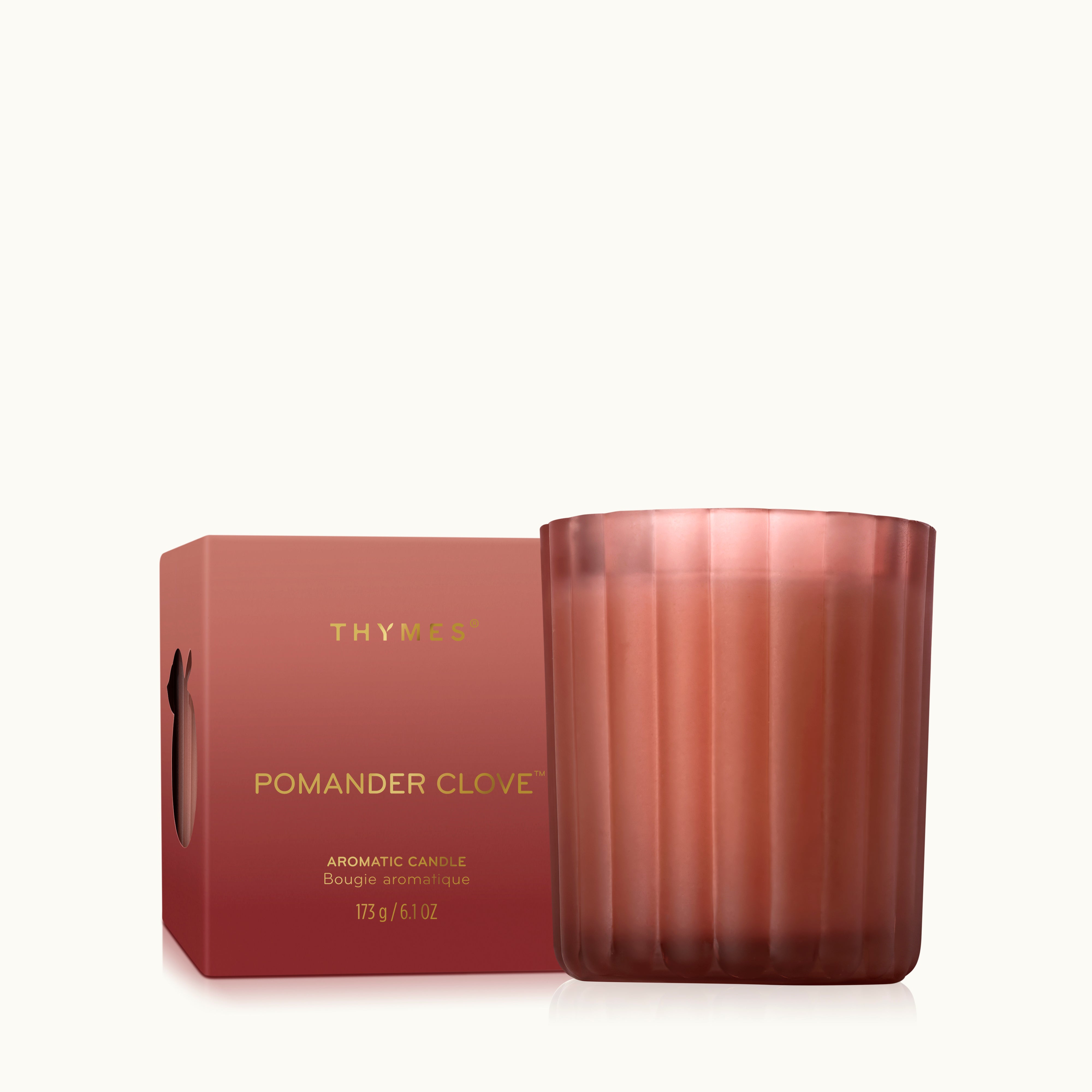 A 6.1 ounce candle in a frosted matte sienna orange glass vessel beside its closed box.