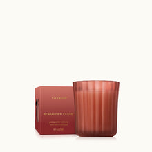 A 2 ounce votive candle in a frosted, matte glass vessel with its matching packaging.