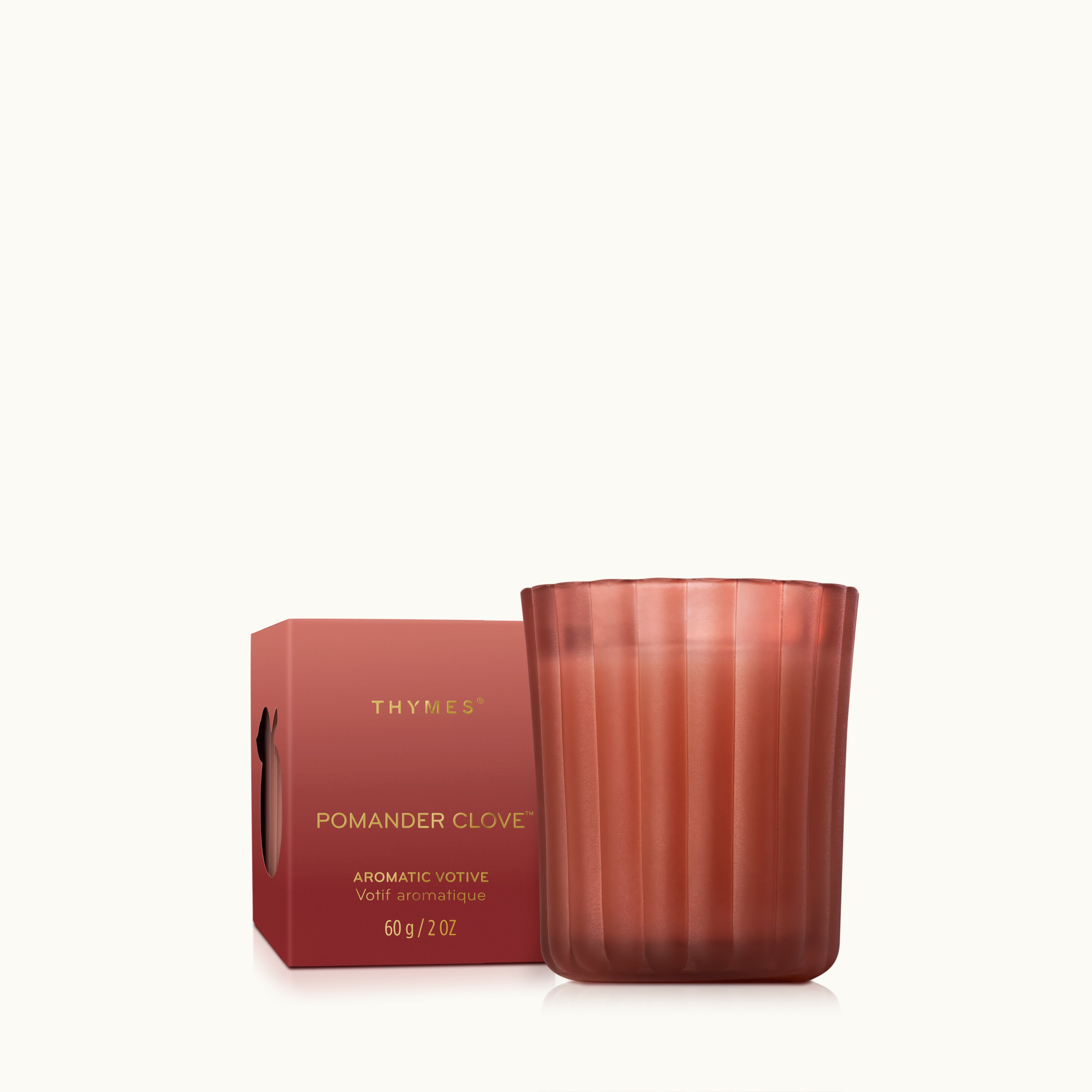 A 2 ounce votive candle in a frosted, matte glass vessel with its matching packaging.