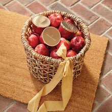 Thymes Simmered Cider Candle Tin with Gold Lid in basket on doormat