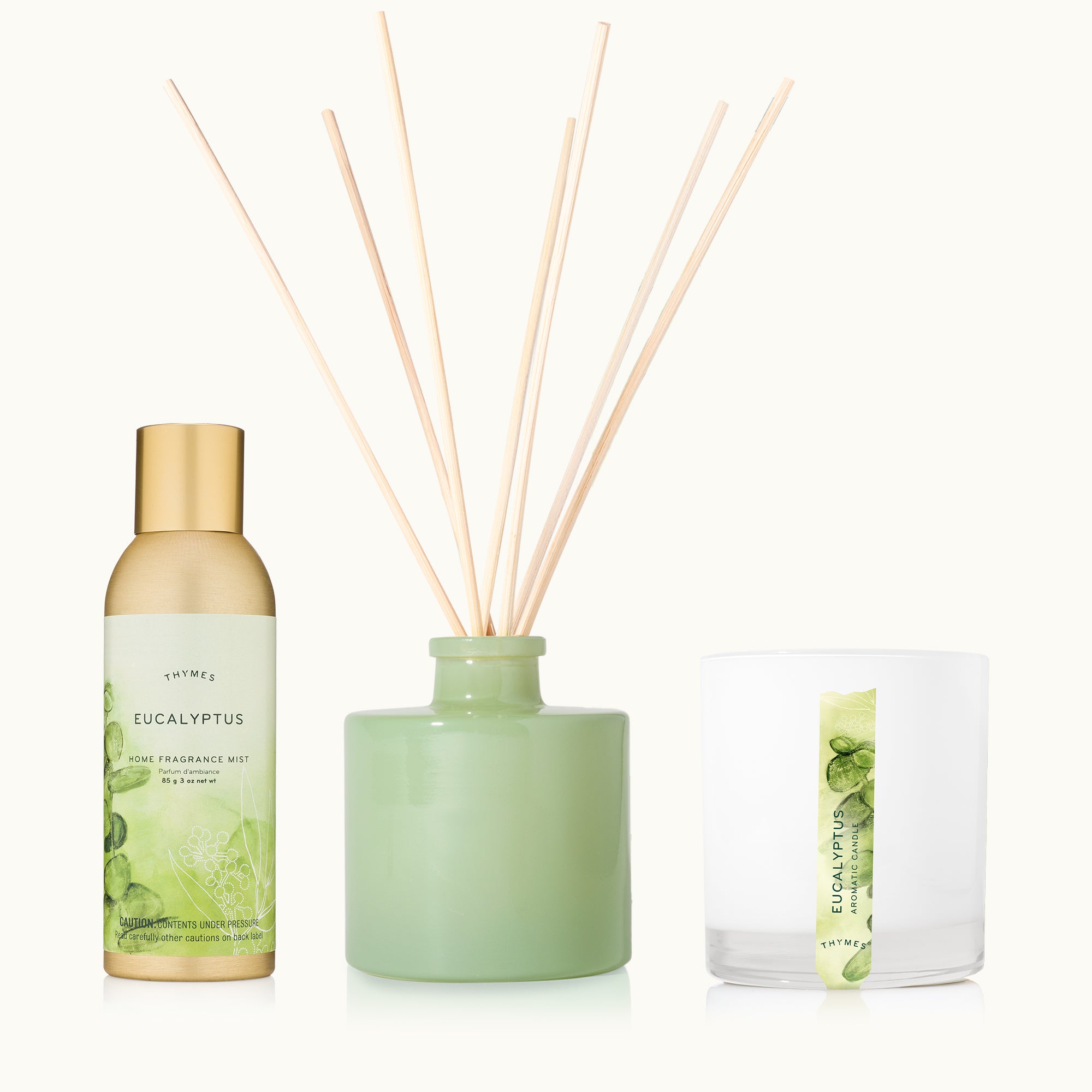 Thymes Eucalyptus Home fragrance Set of diffuser, home fragrance mist, and candle on a tan background