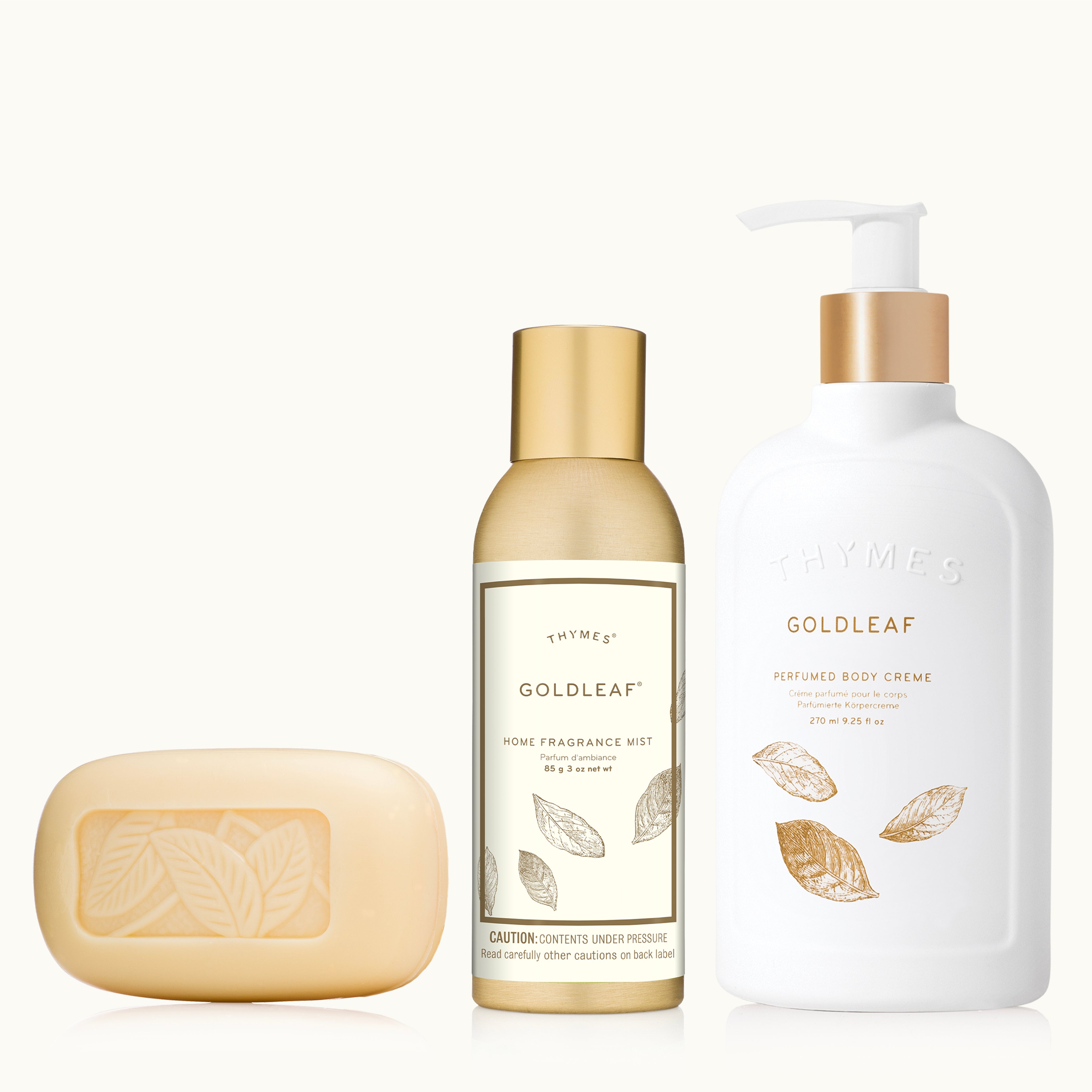 Three Goldleaf bath products including a bar of soap, a bottle of home fragrance mist, and a pump bottle of body cream on a white background.