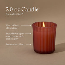 A 2.0 ounce votive candle in a frosted matte sienna orange glass vessel with a lit flame. Text indicates a burn time of up to 16 hours, a non-metal wick, reusable glass vessel, and premium wax blend.