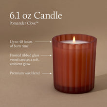 A 6.1 ounce candle in a frosted, matte, sienna orange glass vessel with a lit flame. Text indicates a burn time of up to 40 hours, a frosted ribbed glass vessel that creates a soft, ambient glow, and premium wax blend.