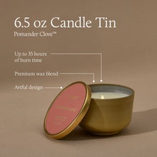 A lit candle tin with a metallic gold finish