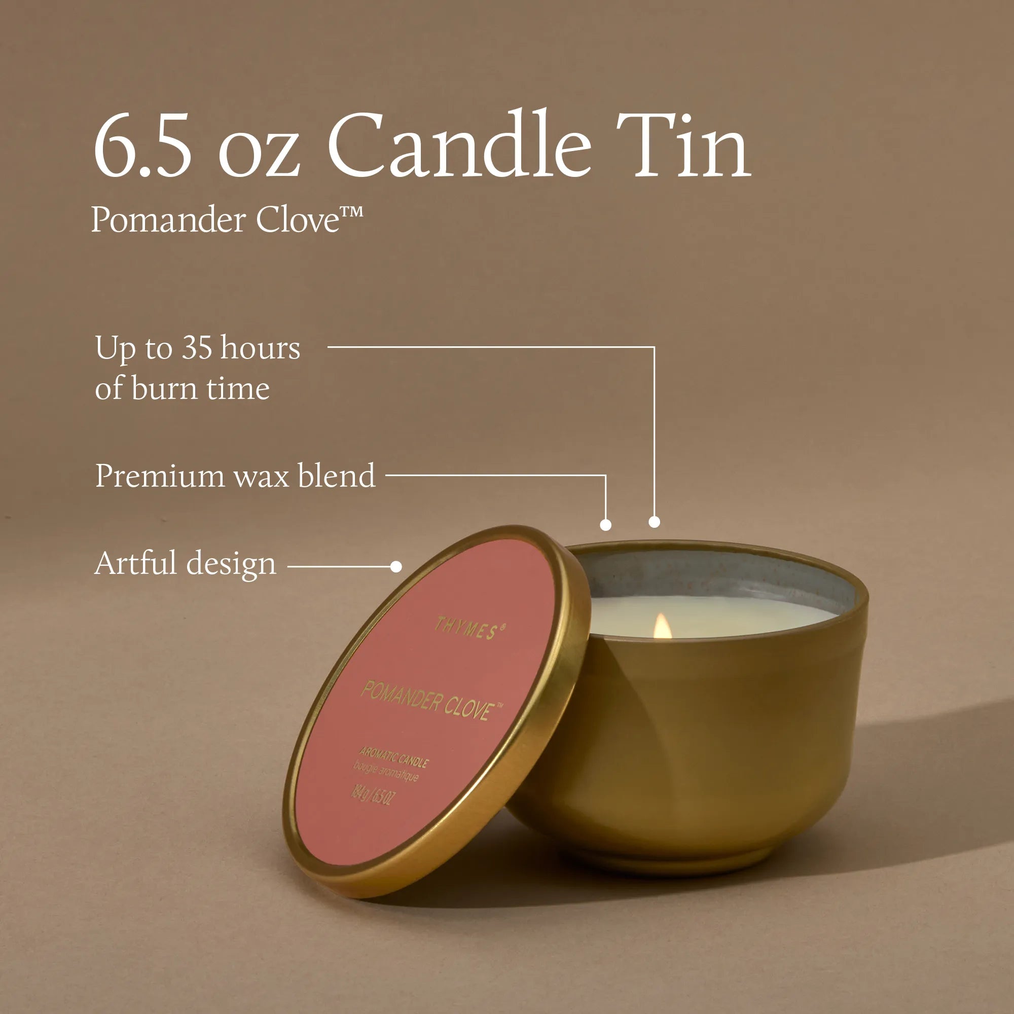 A lit candle tin with a metallic gold finish