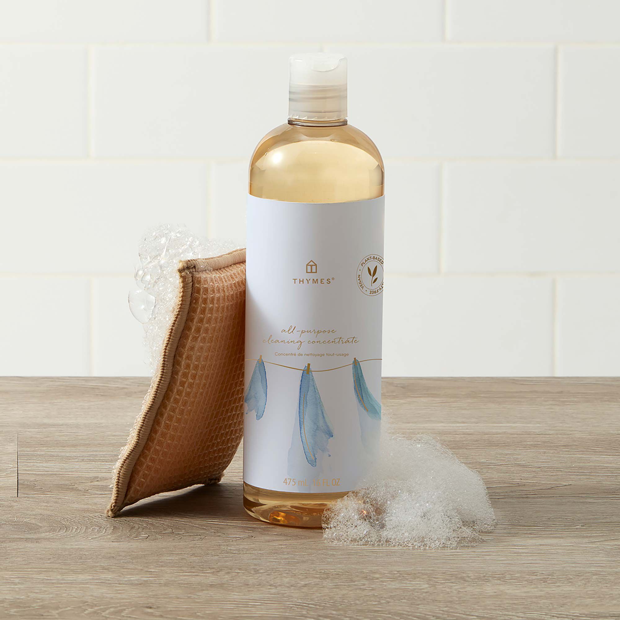 Thymes Washed Linen All-Purpose Cleaning Concentrate for Floors and Surfaces with bubbles and sponge